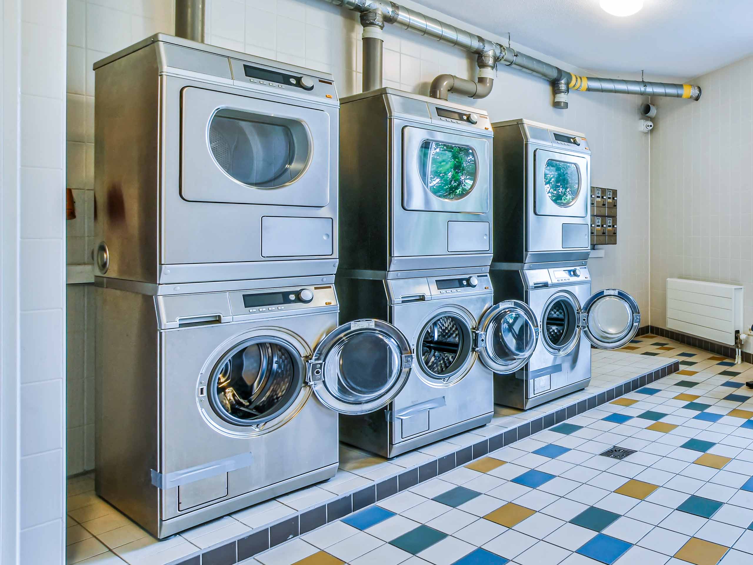 A laundry facility with three sets of washers and driers